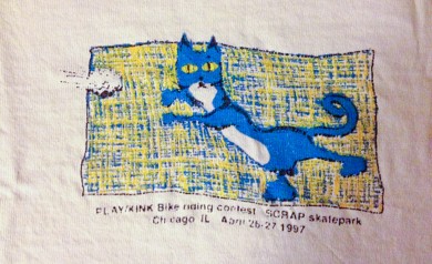 Scamper catching a paperball on a PLAY/Kink contest tee